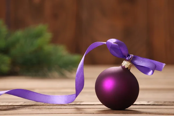 Bola roxa de brinquedo de Natal com fita — Fotografia de Stock