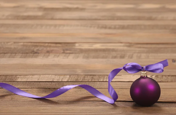 Bola roxa de brinquedo de Natal com fita — Fotografia de Stock