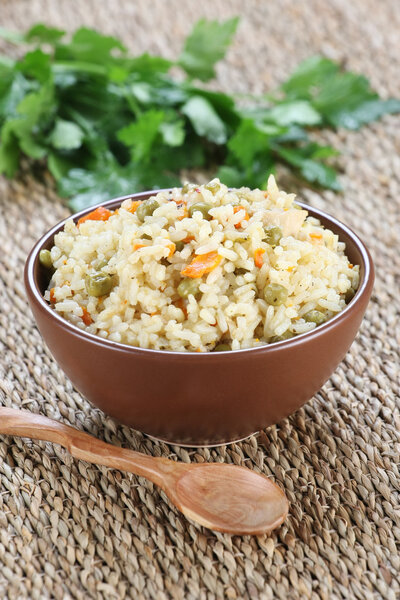 rice with vegetables in a ceramic bowl on a mat 