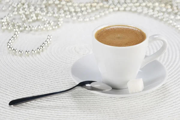 Cup of coffee on a white wicker a mat — Stock Photo, Image
