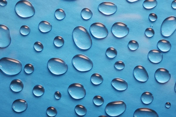 Gocce d'acqua su fondo blu — Foto Stock