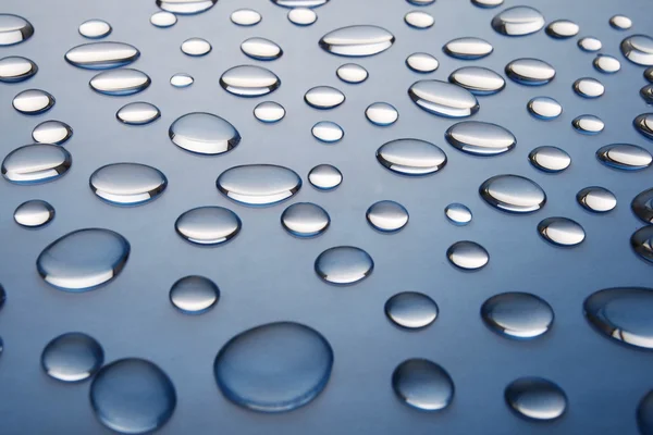 Gocce d'acqua su sfondo sfumato blu scuro — Foto Stock