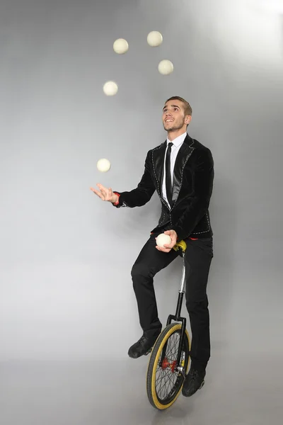 Lächelnder Mann jongliert mit Bällen Stockbild