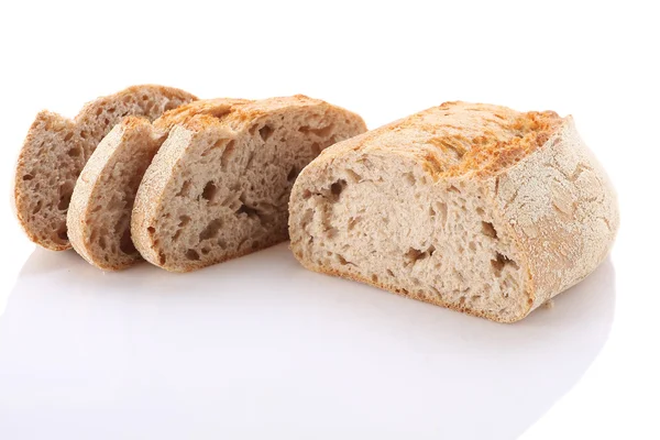 Loaf and slices of bread on a white background — Stock Photo, Image