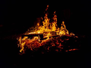 Gece kamp ateşi, odun paleti yanıyor.