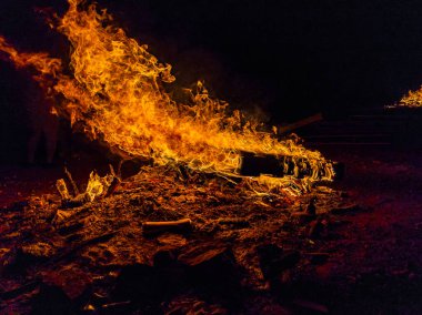 Geceleri küçük kamp ateşine yakın, odun paleti yanıyor.