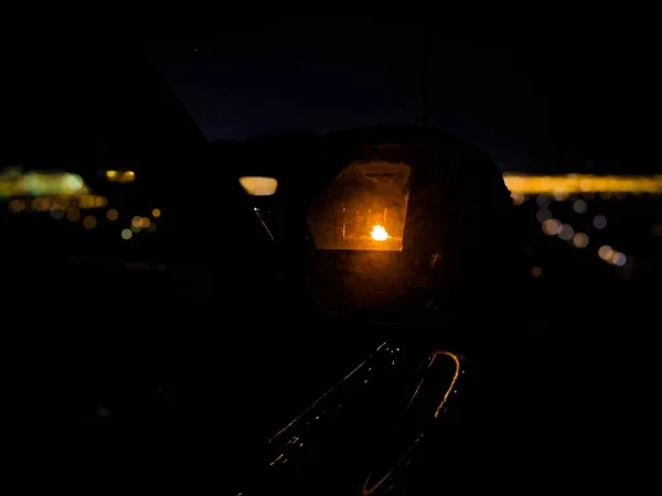 Yeni yıl arifesinde kamp ateşinin etrafında duran insanların araba yan aynasından gece görüşü, arka planda Las Vegas silueti.