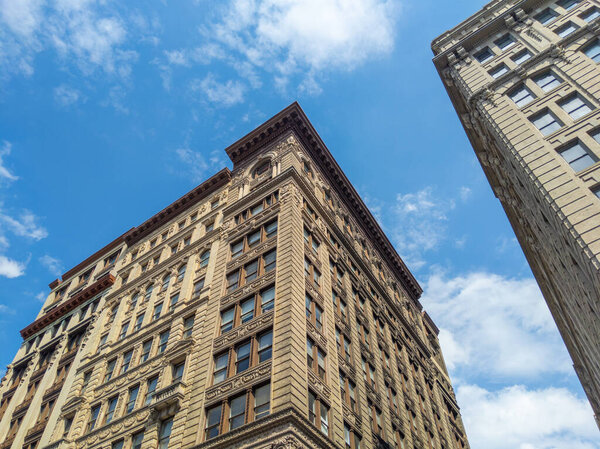 Looking up at old buildings in SoHo, Manhattan, New York City with blue sky