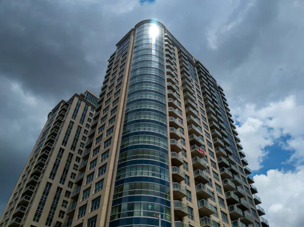 Kanada, Ottawa 'da bulutlu gökyüzü olan yansıtıcı apartman kompleksine bakıyorum.