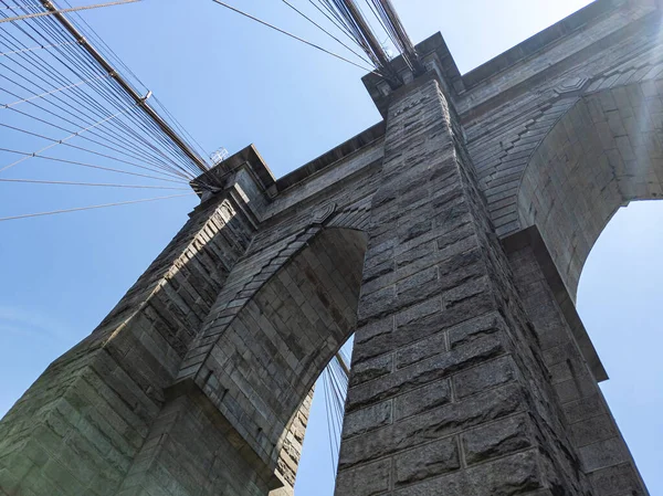 Güneşli bir yaz gününde New York 'taki Brooklyn Köprüsü' ndeki kemerlere bakıyorum.