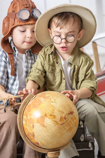 两个小男孩把自己想象成一名飞行员和一名游客 并在一个靠近飞机的地球上探索大陆 — 图库照片
