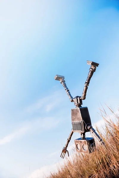 Upside down robot makes wheel against blue sky