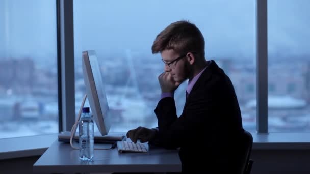 El joven gerente se quedó hasta tarde en el trabajo — Vídeos de Stock