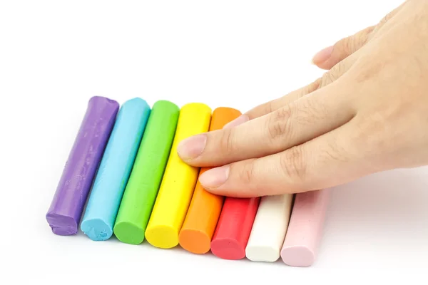 Hand pressing colorful rod plasticine arranging on white backgro — Stock Photo, Image