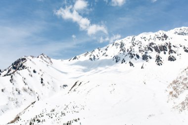 Kar buzlu dağ mavi gökyüzü altında kaplı
