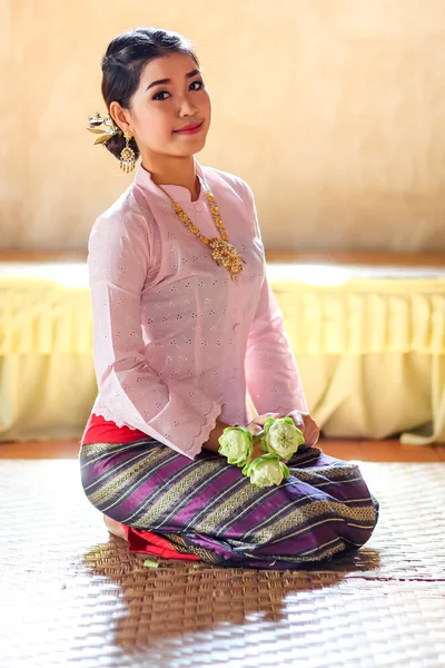 Tailandês menina segurar flor de lótus sentar no templo — Fotografia de Stock