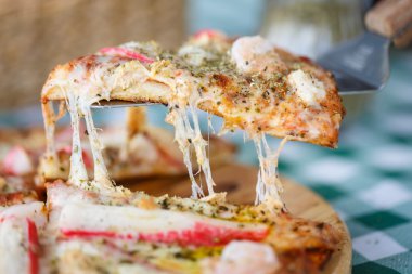 Masanın üzerine hizmet veren deniz ürünleri peynirli pizza