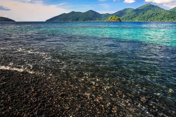 Hermoso mar cristalino con playa de guijarros negro — Foto de Stock