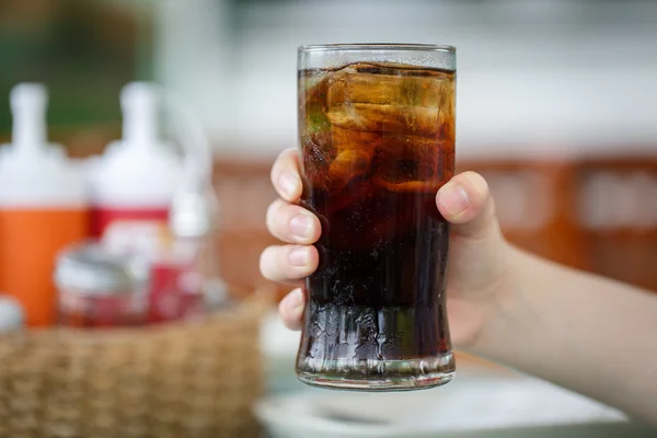 Mão segurando vidro de bebida cola — Fotografia de Stock