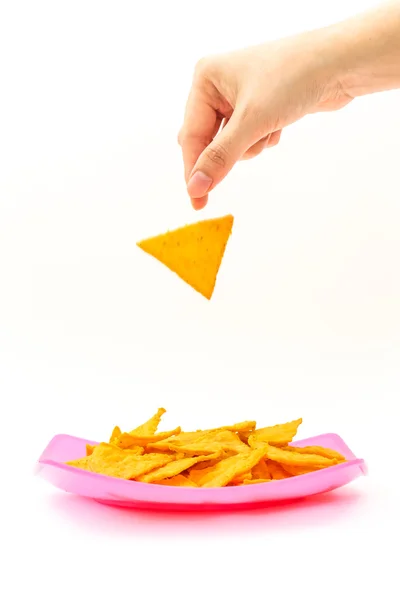 Picking tortilla chips from colorful dish on white background — Stock Photo, Image