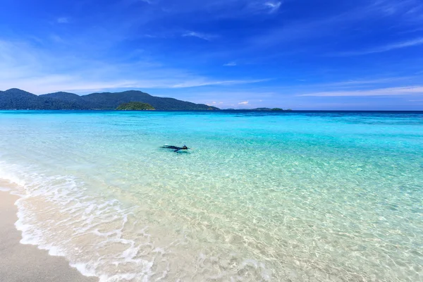 Hombre haciendo snorkel en aguas cristalinas de color turquesa en la playa tropical —  Fotos de Stock