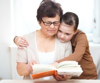 Büyükanne torunu ile kitap okuyor