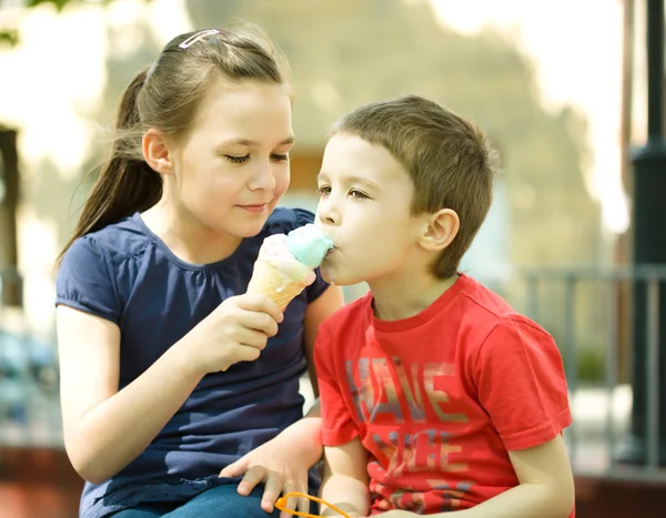 Girl is feeding his little brother with ice-cream — Stock Photo, Image