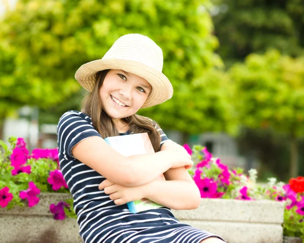 Girl is reading a book outdoors — Stock Photo, Image