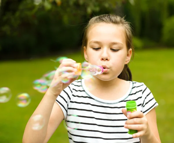 Girl is blowing a soap bubbles — Stock Photo, Image