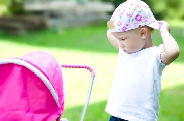 Kız bebek için çocuk arabası ile oynamaktan — Stok fotoğraf