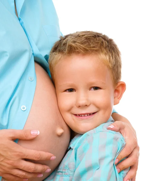 Niño feliz sosteniendo el vientre de la mujer embarazada —  Fotos de Stock