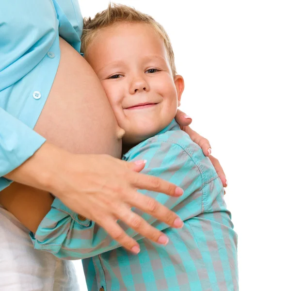 Criança feliz segurando barriga de mulher grávida — Fotografia de Stock