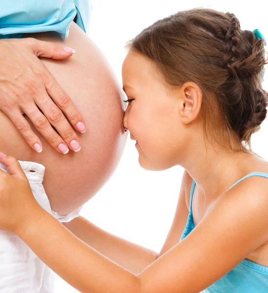 Счастливый ребенок с животом беременной женщины — стоковое фото