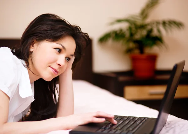 Jonge vrouw speelt op laptop — Stockfoto