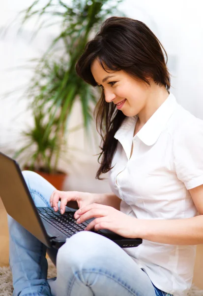 Jonge vrouw speelt op laptop — Stockfoto