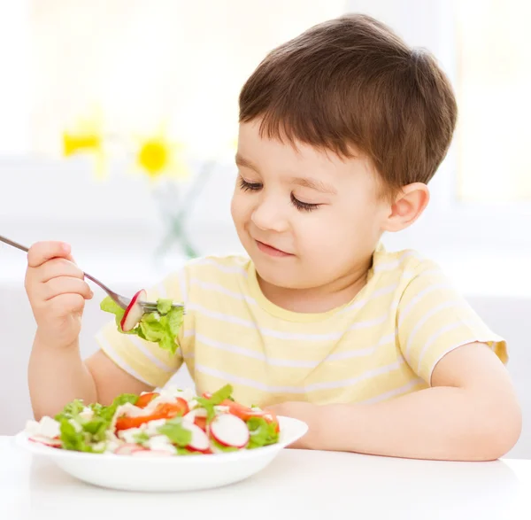 Ładny mały chłopiec jest jedzenie warzywo sałatka — Zdjęcie stockowe