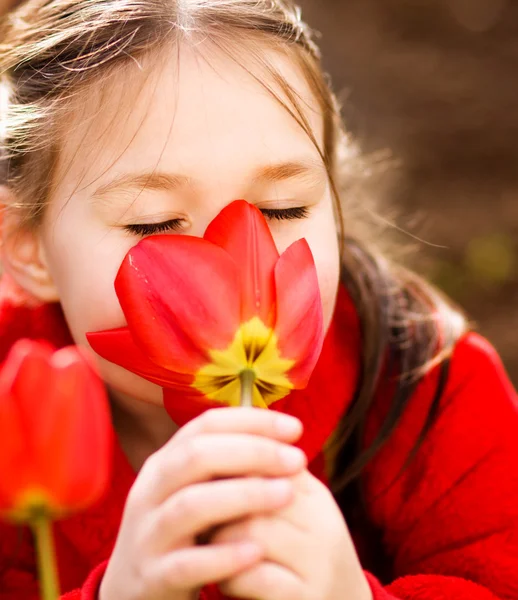 小さな女の子の臭いがする花アウトドア — ストック写真