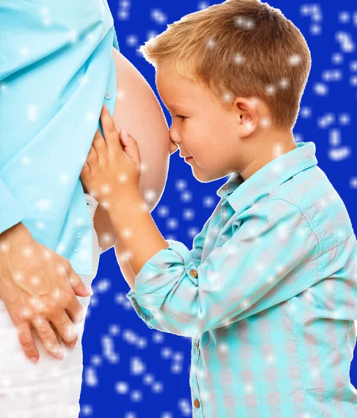 Niño feliz sosteniendo el vientre de la mujer embarazada —  Fotos de Stock