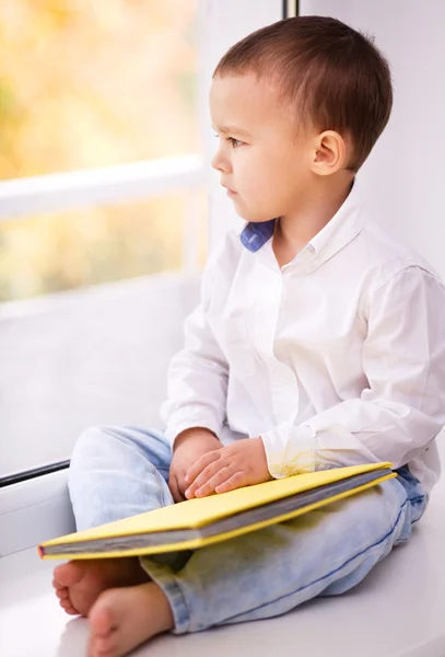 Liten pojke läser en bok — Stockfoto