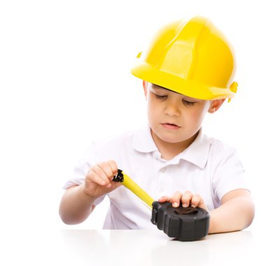 Çocuk mezura ile bir inşaat işçisi olarak