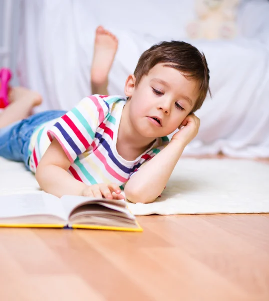 Liten pojke läser en bok — Stockfoto