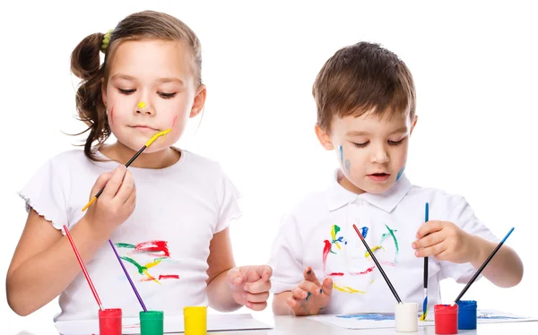 Симпатичные мальчик и девочка играют с красками — стоковое фото