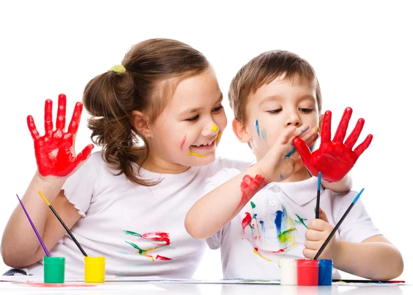 Şirin bir çocuk ve boyalar ile oynayan kız — Stok fotoğraf