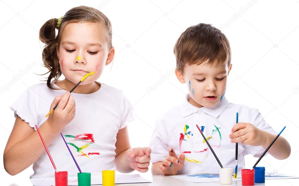 Cute boy and girl playing with paints
