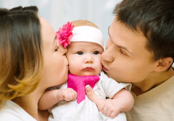 Родители целуют ребенка — стоковое фото