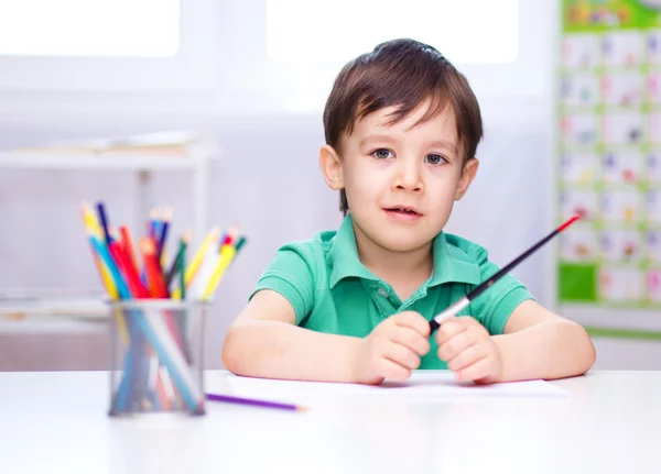 Kleine jongen loopt op wit papier — Stockfoto