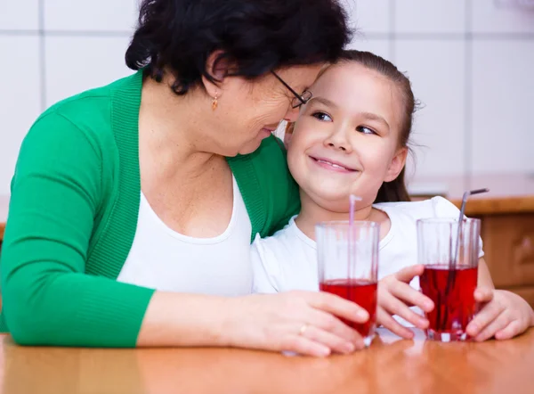 Grand-mère et ses petits-enfants boivent du jus — Photo