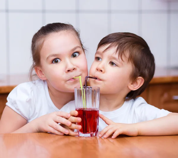 Chica y niño beber jugo —  Fotos de Stock