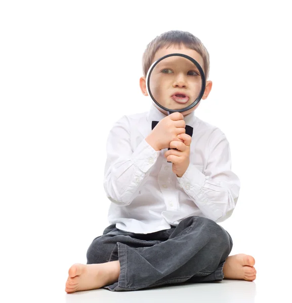 Cute little boy is playing with magnifier — Stock Photo, Image