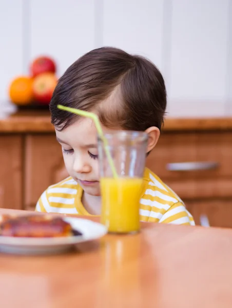 Mały chłopiec z kieliszek soku pomarańczowego — Zdjęcie stockowe